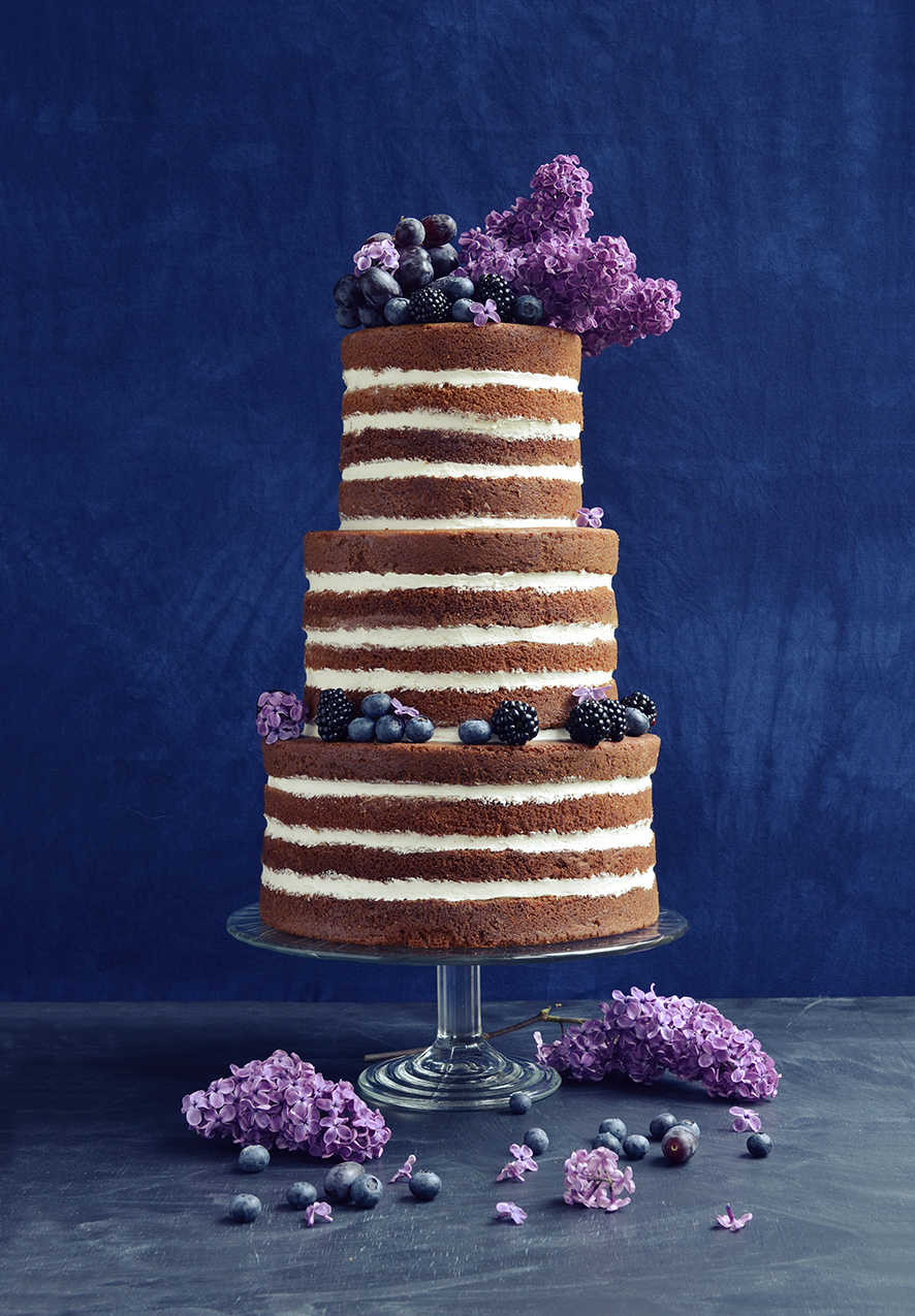 Naked wedding cake with lilacs and blue fruit